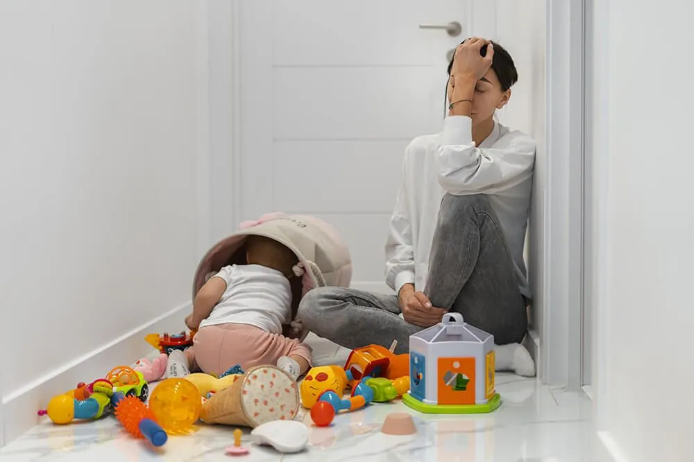 Maman fatigue à côté d'un enfant qui joue
